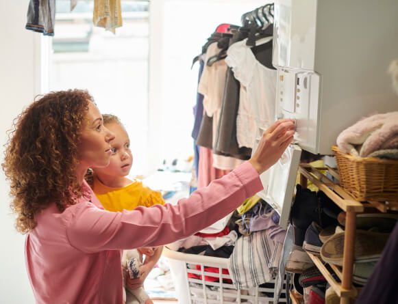 mother and daughter in the utility room adjusting the heat of the house