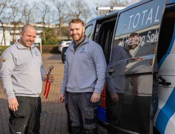 Smiling gas, heating and plumbing engineers with tools ready to help a customers in the sun